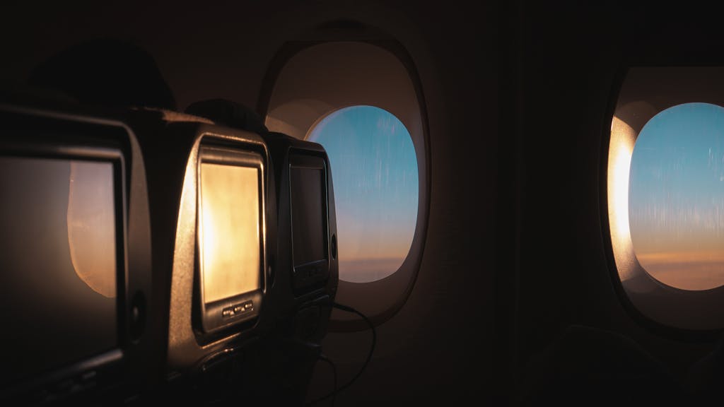 Tranquil view from an airplane window seat showcasing the sunset sky and cabin interior.
