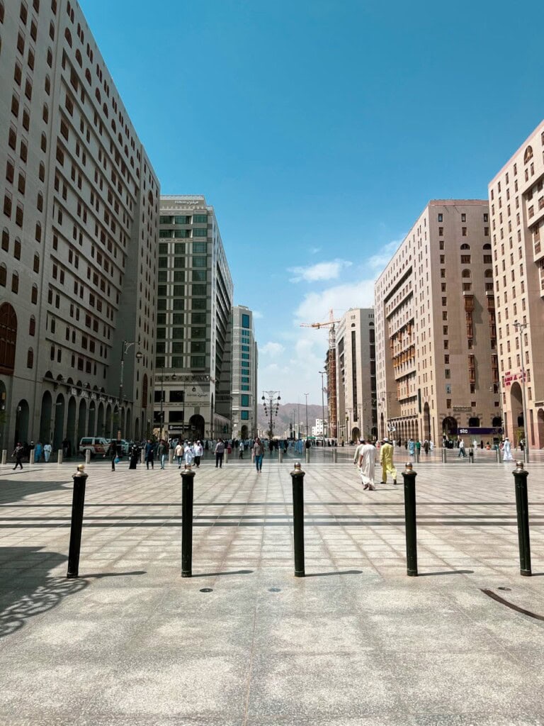 people walking on city street between concrete buildings